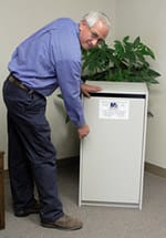 employee opening a shredding unit