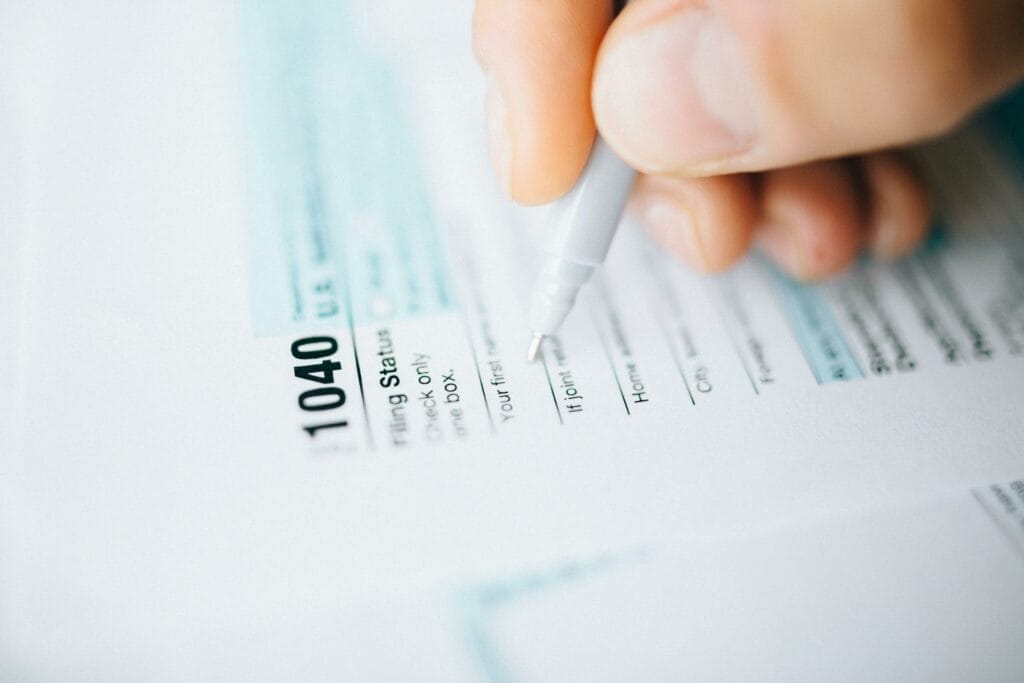 Filling out IRS Form 1040 with a pen.
